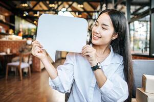 foto een jong vrouw in een wit overhemd Holding een gedachte doos symbool