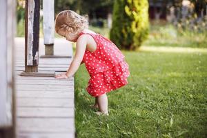 weinig meisje spelen alleen in de tuin foto