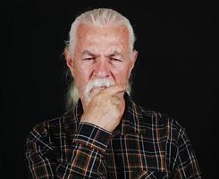 de oud Mens houdt zijn baard en denken foto