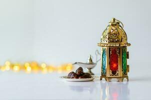 gouden lantaarn met datums fruit Aan wit achtergrond met lichten voor de moslim feest van de heilig maand van Ramadan kareem. foto