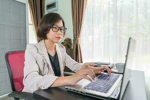 jong vrouw in slim gewoontjes slijtage werken Aan laptop foto