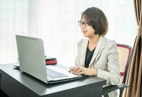 jong vrouw in slim gewoontjes slijtage werken Aan laptop foto