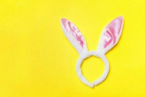 gelukkig Pasen concept. decoratief konijn oren harig kostuum speelgoed- geïsoleerd Aan modieus geel achtergrond foto