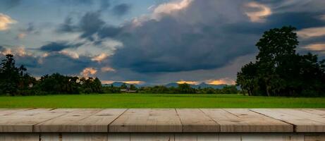 rijst- veld- zonsondergang en leeg hout tafel voor Product Scherm en montage. foto