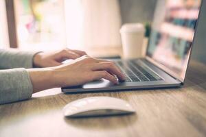 bedrijf vrouw gebruik makend van laptop computer Doen online werkzaamheid Aan hout tafel Bij huis kantoor. foto