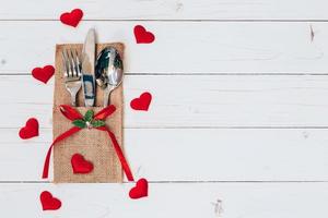 bovenstaand hout tafel reeks zilverwerk en rood hart voor Valentijn dag met ruimte. foto