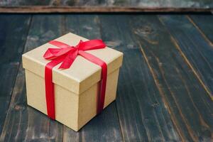 bruin geschenk doos Aan houten tafel met kopiëren ruimte. foto