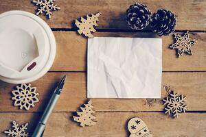 top visie koffie kop en pen, blanco papier Aan hout met Kerstmis decoratie voor nieuw jaar concept. foto
