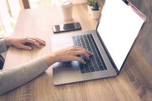 bedrijf vrouw gebruik makend van laptop computer Doen online werkzaamheid Aan hout tafel Bij huis kantoor. foto