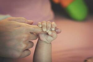 pasgeboren baby aanraken zijn moeder hand- foto