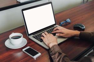 bedrijf Mens hand- sms'en laptop Aan houten tafel foto