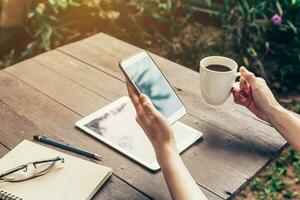 dichtbij omhoog van vrouw hand- Holding telefoon met blanco kopiëren ruimte scherm voor uw reclame. hand- vrouw gebruik makend van telefoon in koffie winkel. foto