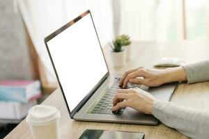 bedrijf vrouw hand- typen laptop computer Aan houten tafel foto