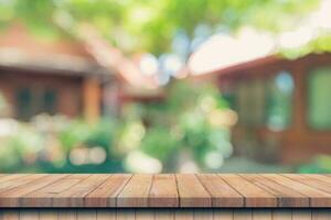 leeg hout tafel en onscherp bokeh en vervagen achtergrond van tuin bomen met zonlicht. Product Scherm sjabloon. foto