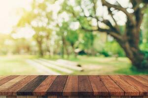 abstract wazig tuin en groen blad met houten tafel teller achtergrond voor tonen , promoten ,ontwerp Aan Scherm concept foto