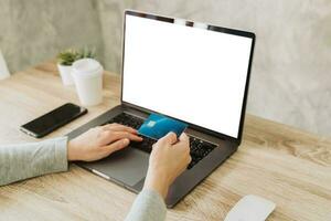 vrouw hand- Holding credit kaart en gebruik makend van laptop voor boodschappen doen online foto