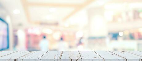 leeg hout tafel en wazig licht tafel in boodschappen doen winkelcentrum met bokeh achtergrond. Product Scherm sjabloon. foto