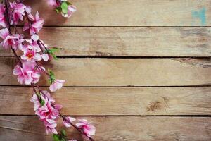 kers bloesem en kunstmatig bloemen Aan wijnoogst houten achtergrond met kopiëren ruimte. foto