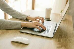 bedrijf vrouw gebruik makend van laptop computer Doen online werkzaamheid Aan hout tafel Bij huis kantoor. foto