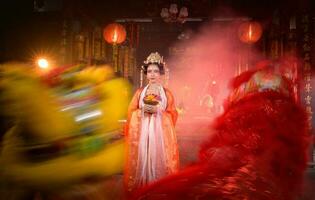 Chinese vrouw met geel en rood leeuwen het is beschouwd naar verbeteren de welvaart voor zichzelf Aan de gelegenheid van de Chinese nieuw jaar festival elke jaar foto