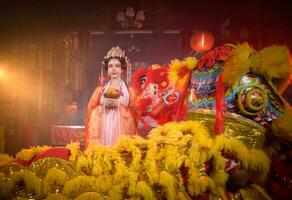 Chinese vrouw met geel en rood leeuwen het is beschouwd naar verbeteren de welvaart voor zichzelf Aan de gelegenheid van de Chinese nieuw jaar festival elke jaar foto