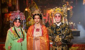 mannetje en vrouw Chinese opera acteurs licht een kaars naar bidden hulde naar de goden naar verbeteren de welvaart voor jezelf Aan de gelegenheid foto