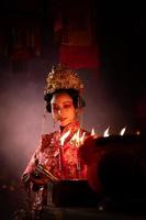 Chinese vrouw maken wensen, bidden, en licht kaarsen. Aan de gelegenheid van de jaar- Chinese nieuw jaar festival, in een vereerd altaar of tempel foto