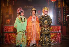 mannetje en vrouw Chinese opera acteurs licht een kaars naar bidden hulde naar de goden naar verbeteren de welvaart voor jezelf Aan de gelegenheid foto