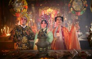 mannetje en vrouw Chinese opera acteurs licht een kaars naar bidden hulde naar de goden naar verbeteren de welvaart voor jezelf Aan de gelegenheid foto