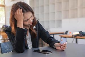 jong Aziatisch vrouw boodschappen doen online gebruik makend van een credit kaart. voor online betaling binnen de huis credit kaart betaling concept foto