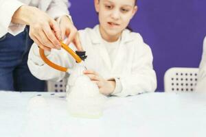 jongen studie wetenschap onderwijs. chemisch laboratorium met test buizen voor experimenten en veelkleurig vloeistoffen foto