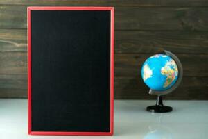 schoolbord mock-up frame en wereldbolmodel op tafel foto