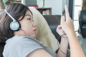 Aziatisch vrouw kort haar- luisteren muziek- foto