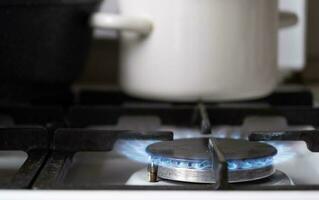 ontsteking van de gas- brander Aan de fornuis in de keuken. gebruik van natuurlijk bronnen, economie, Koken Aan brand. detailopname foto