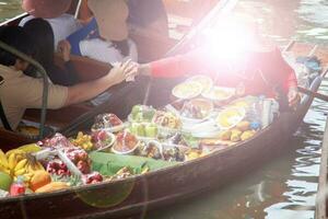 boten verkoop divers soorten van fruit Bij damnoen saduak drijvend markt zijn een populair toerist bestemming dat Europeanen en Chinese Leuk vinden naar reizen met de traditioneel manier van leven van de dorpelingen. foto