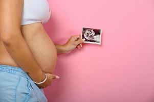 zwanger mam shows een echografie van haar zoon foto