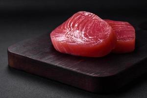twee vers plakjes van rauw tonijn filet met specerijen en kruiden foto