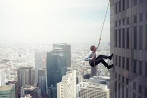 zakenman klimt een gebouw met een touw. concept van bepaling foto