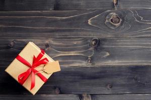 bruin geschenk doos Aan rustiek hout achtergrond met ruimte voor tekst. foto