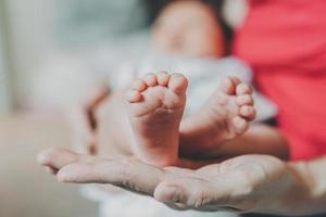 voeten van een pasgeboren baby in de handen van moeder. foto