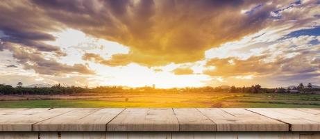 rijst- veld- zonsondergang en leeg hout tafel voor Product Scherm en montage. foto