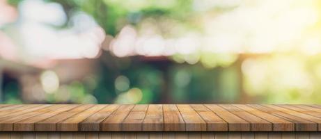 leeg hout tafel en onscherp bokeh en vervagen achtergrond van tuin bomen met zonlicht. Product Scherm sjabloon. foto