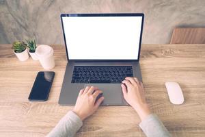 bedrijf vrouw gebruik makend van laptop computer Doen online werkzaamheid Aan hout tafel Bij huis kantoor. foto