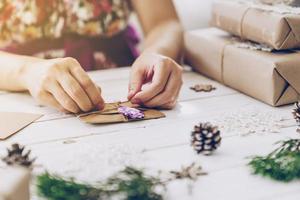 vrouw hand- maken mooi Kerstmis kaart Bij tafel foto