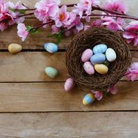 kers bloesem bloemen en Pasen ei in nest Aan wijnoogst houten achtergrond met kopiëren ruimte. foto
