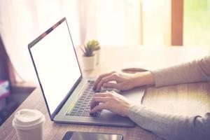 bedrijf vrouw gebruik makend van laptop computer Doen online werkzaamheid Aan hout tafel Bij huis kantoor. foto