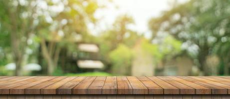 leeg hout tafel en onscherp bokeh en vervagen achtergrond van tuin bomen met zonlicht. Product Scherm sjabloon. foto