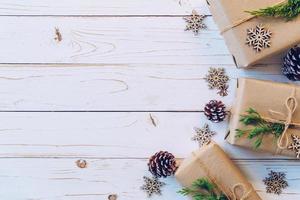 eigengemaakt verpakt Kerstmis geschenk doos presenteert Aan een hout tafel achtergrond. foto