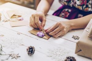 vrouw hand- maken mooi Kerstmis kaart Bij tafel foto