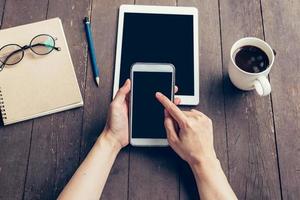 dichtbij omhoog van vrouw hand- Holding telefoon met blanco kopiëren ruimte scherm voor uw reclame. hand- vrouw gebruik makend van telefoon in koffie winkel. foto